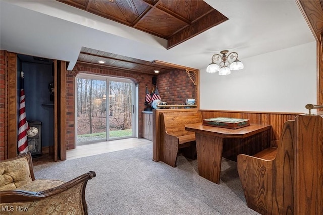 interior space with wooden ceiling, an inviting chandelier, brick wall, wood walls, and light colored carpet