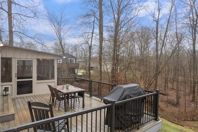 wooden terrace featuring grilling area and a sunroom