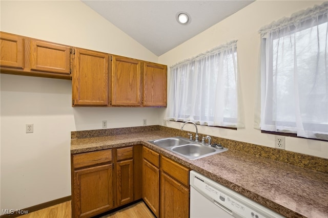 kitchen with dishwasher, light hardwood / wood-style flooring, vaulted ceiling, and sink