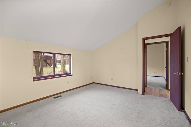 interior space with light colored carpet and vaulted ceiling