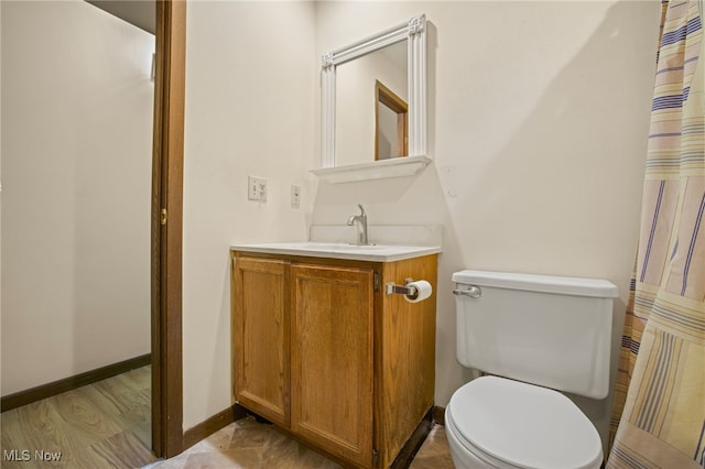 bathroom featuring vanity, hardwood / wood-style flooring, and toilet