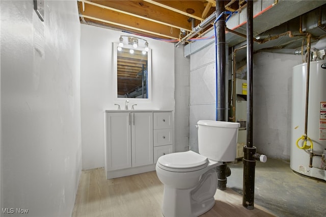 bathroom featuring water heater, hardwood / wood-style floors, vanity, and toilet