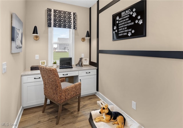 office space featuring built in desk and light hardwood / wood-style floors