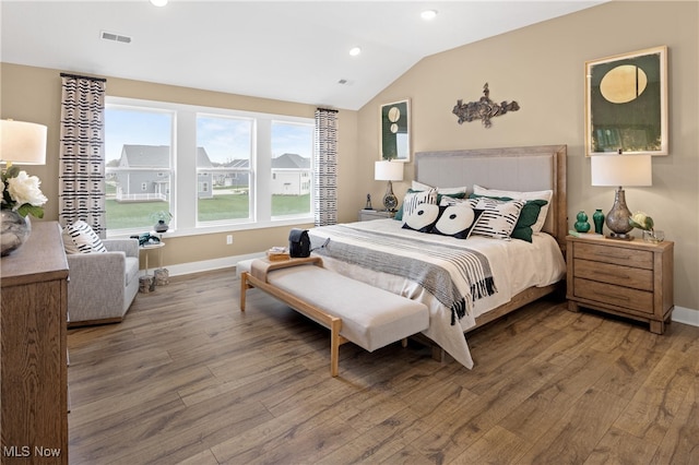 bedroom with hardwood / wood-style floors and lofted ceiling