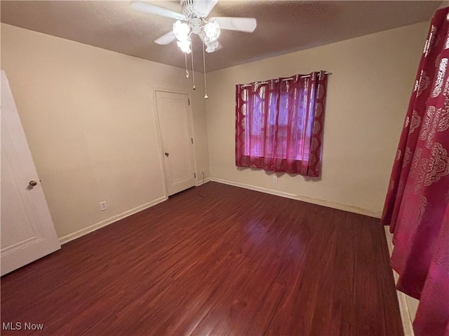 spare room featuring ceiling fan and dark hardwood / wood-style floors