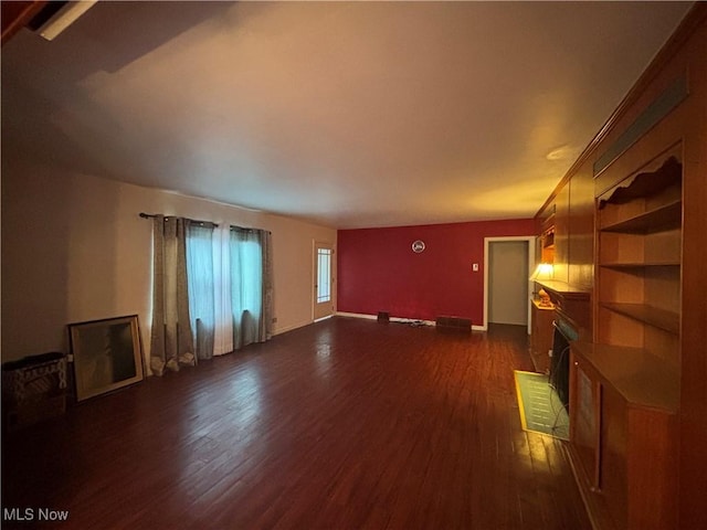 unfurnished living room featuring a fireplace and dark wood-type flooring