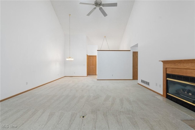 unfurnished living room with light colored carpet, high vaulted ceiling, and ceiling fan