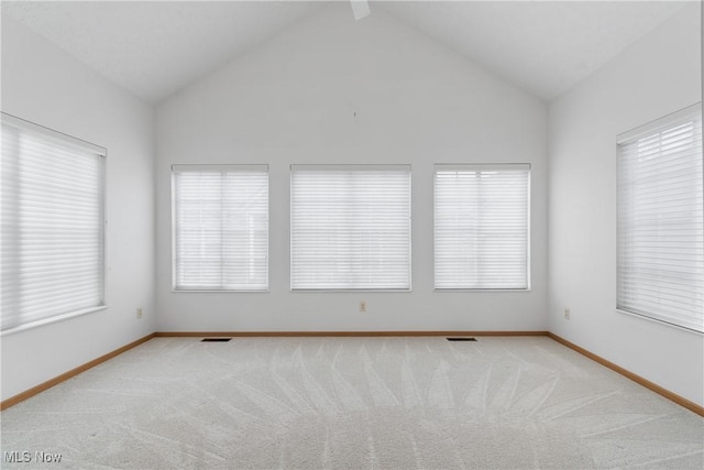 carpeted empty room with lofted ceiling