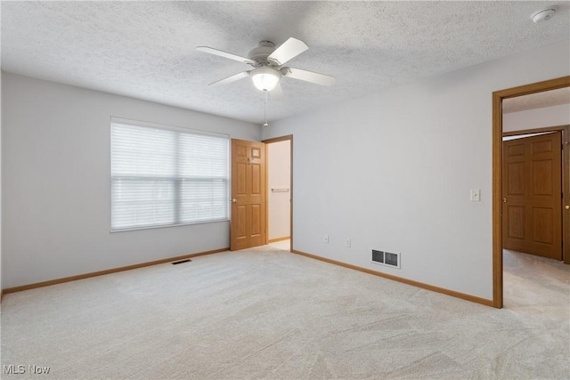 carpeted empty room with ceiling fan and a textured ceiling