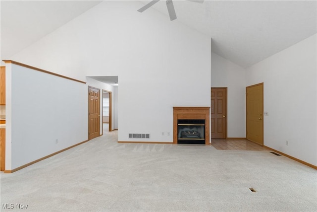 unfurnished living room featuring light carpet, high vaulted ceiling, and ceiling fan