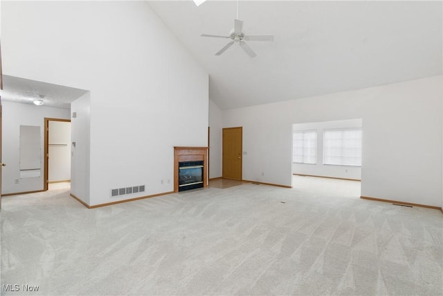 unfurnished living room with ceiling fan, light colored carpet, and high vaulted ceiling