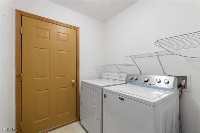 laundry area featuring a textured ceiling and washer and clothes dryer