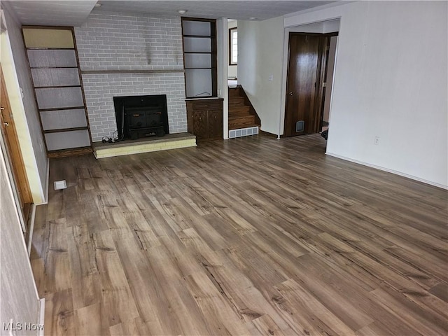 unfurnished living room featuring a fireplace and hardwood / wood-style floors