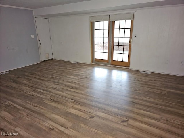 unfurnished room featuring dark wood-type flooring and ornamental molding