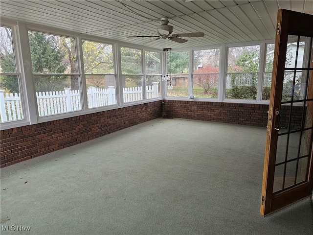 unfurnished sunroom featuring ceiling fan and wood ceiling