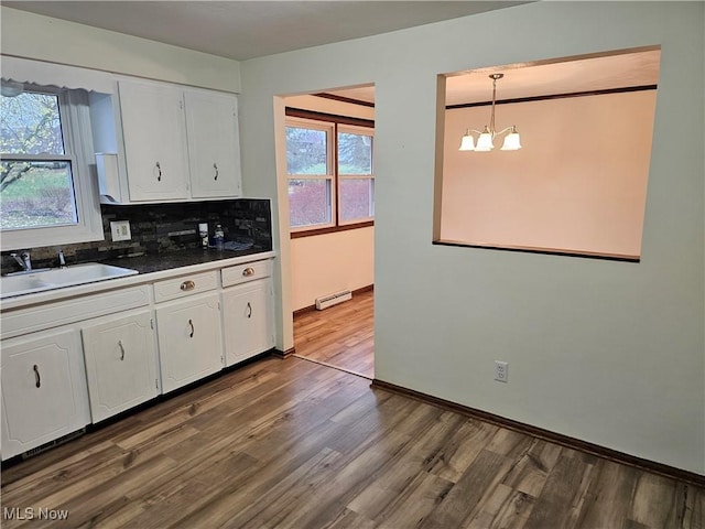 kitchen with decorative light fixtures, white cabinetry, a healthy amount of sunlight, and sink