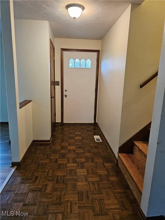 entryway with dark parquet floors