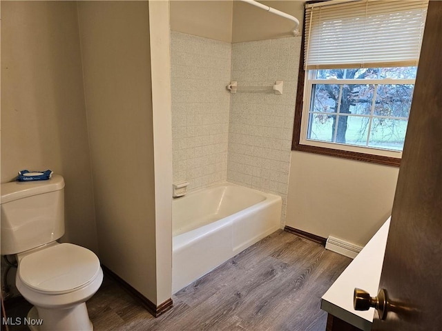 full bathroom with vanity, baseboard heating, hardwood / wood-style floors, toilet, and tiled shower / bath