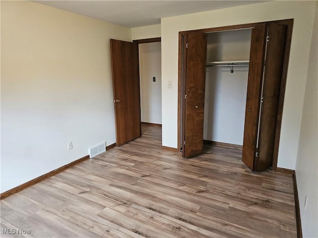 unfurnished bedroom with light hardwood / wood-style floors and a closet