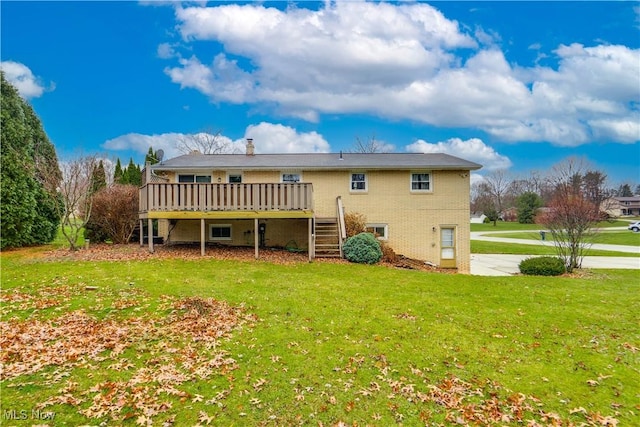 rear view of property featuring a deck and a lawn