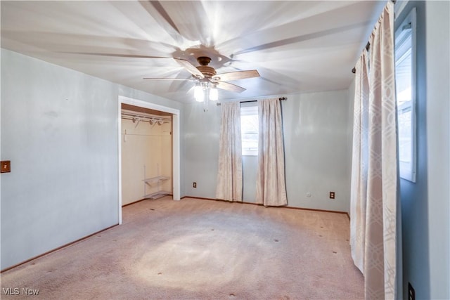 unfurnished bedroom featuring ceiling fan, a closet, and light carpet