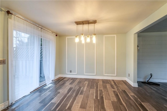 unfurnished dining area with a chandelier and dark hardwood / wood-style floors