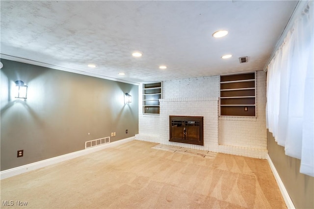 unfurnished living room with a textured ceiling, a fireplace, carpet, and built in features