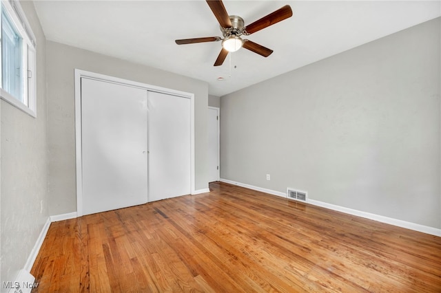 unfurnished bedroom with a closet, light hardwood / wood-style floors, and ceiling fan