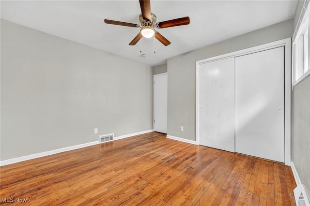 unfurnished bedroom featuring ceiling fan, a closet, and light hardwood / wood-style flooring