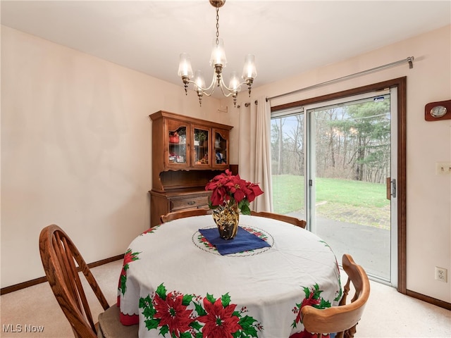 dining space with light carpet and a chandelier