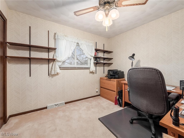 carpeted office space with ceiling fan