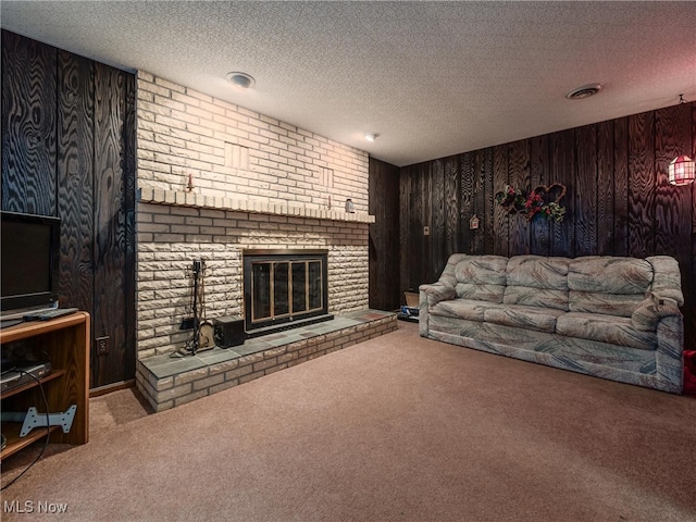 living room with wood walls, carpet floors, a textured ceiling, and a brick fireplace