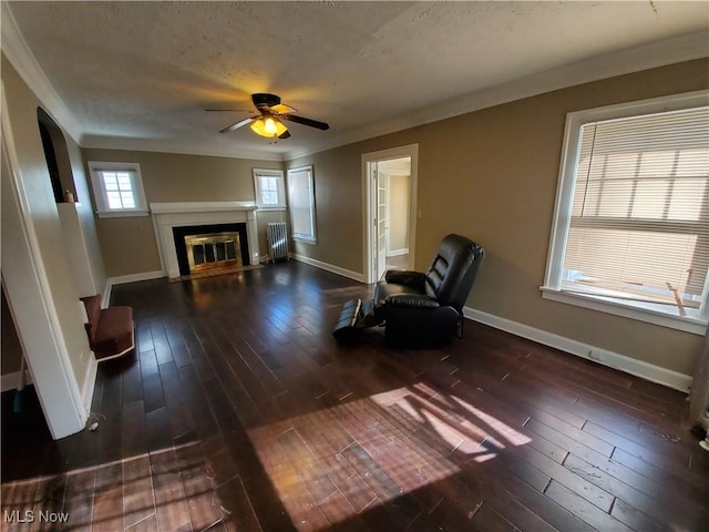 unfurnished room with ceiling fan, radiator heating unit, dark wood-type flooring, and ornamental molding