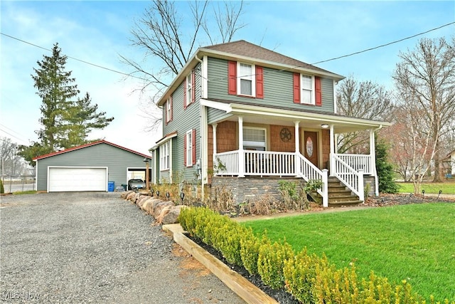 front facade featuring a front yard, covered porch, an outdoor structure, and a garage