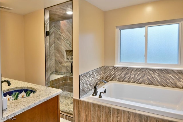 bathroom with shower with separate bathtub and vanity