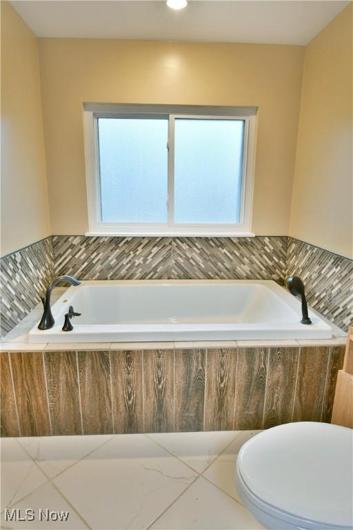 bathroom with tiled bath and toilet