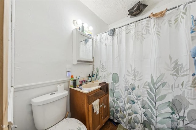 bathroom with vanity, a shower with curtain, a textured ceiling, and toilet