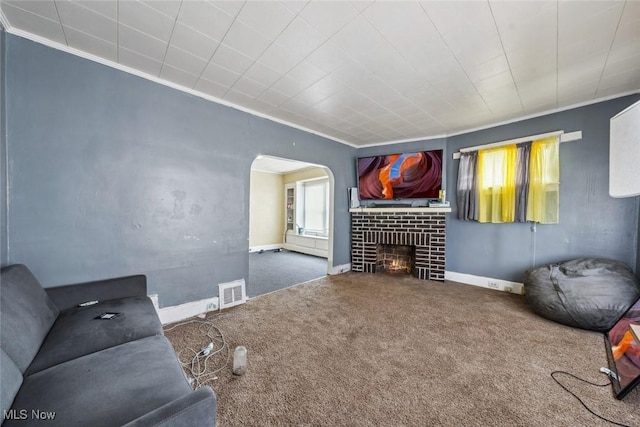 living room with carpet, ornamental molding, and a fireplace