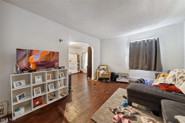 living room featuring a textured ceiling and dark hardwood / wood-style floors