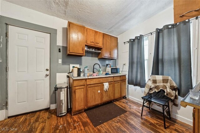 kitchen featuring dark hardwood / wood-style flooring, a textured ceiling, and sink