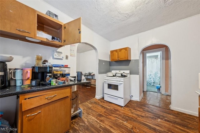 kitchen with a textured ceiling, dark wood-type flooring, and white gas stove