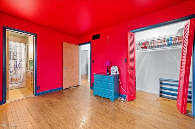 bedroom with connected bathroom, a closet, and light hardwood / wood-style flooring