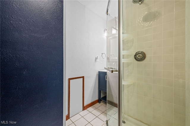 bathroom with tile patterned flooring, vanity, and a shower with door