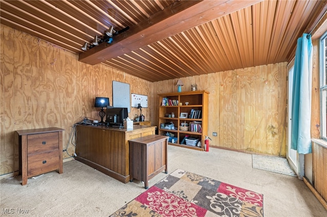 office area with light carpet, beam ceiling, and wood walls