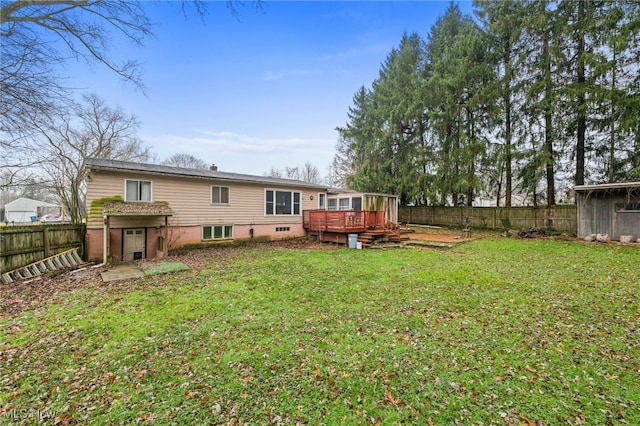 rear view of house featuring a yard and a deck