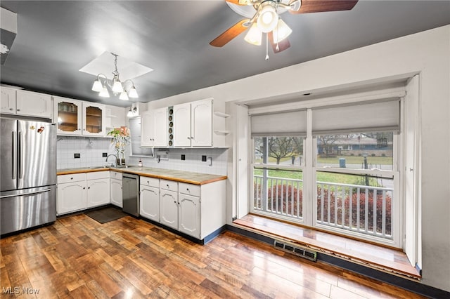 kitchen with decorative backsplash, appliances with stainless steel finishes, sink, white cabinets, and dark hardwood / wood-style floors