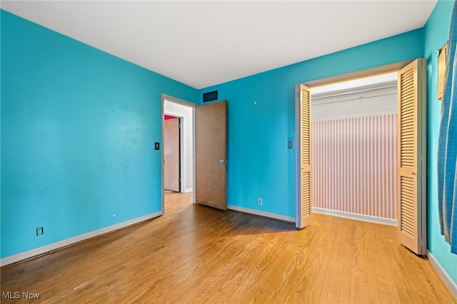 unfurnished bedroom featuring light hardwood / wood-style floors and a closet