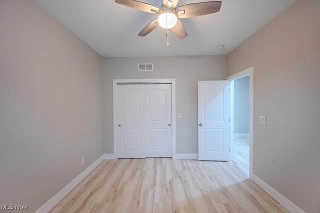 unfurnished bedroom featuring light hardwood / wood-style floors, a closet, and ceiling fan