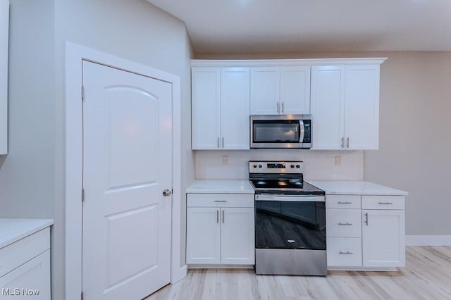 kitchen featuring white cabinetry, light hardwood / wood-style floors, and appliances with stainless steel finishes