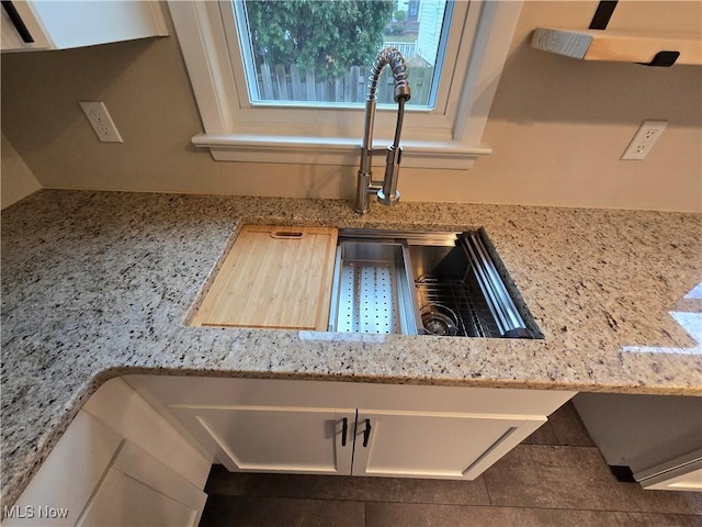 room details with light stone countertops and white cabinets